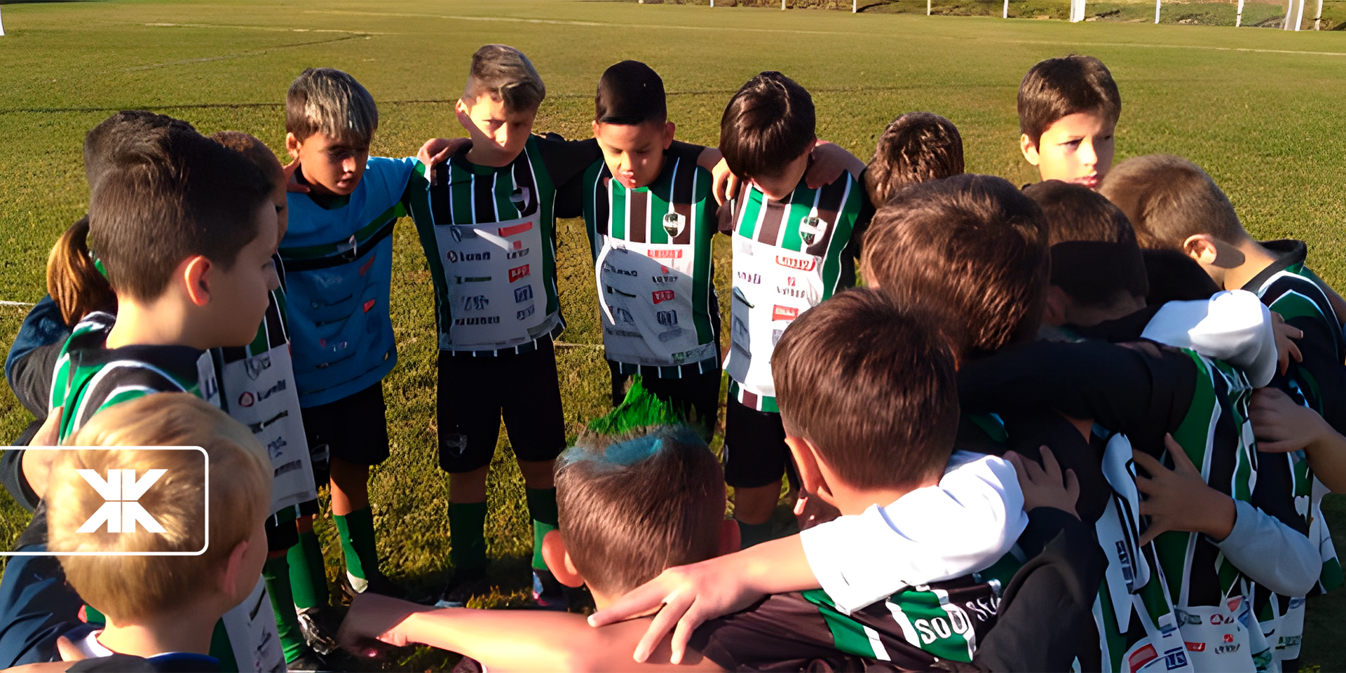 Time infantil de futebol unido em círculo antes da partida.